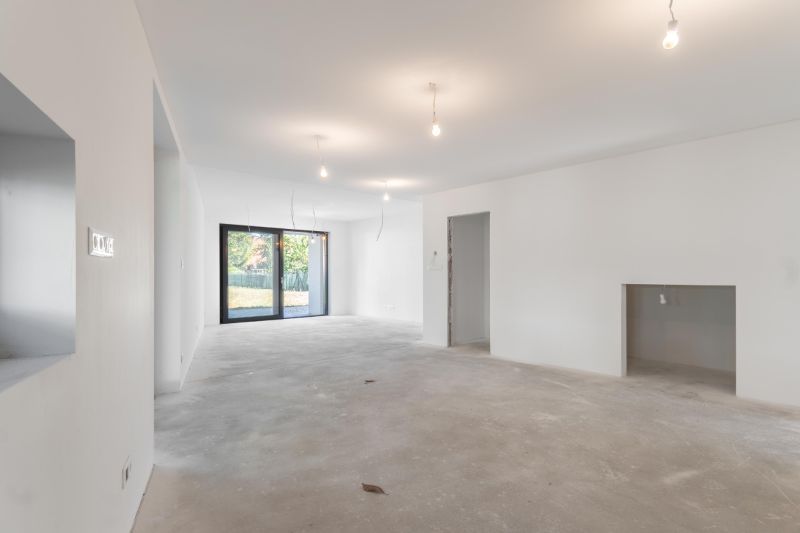 A spacious living room in a family house with large French windows and white walls.