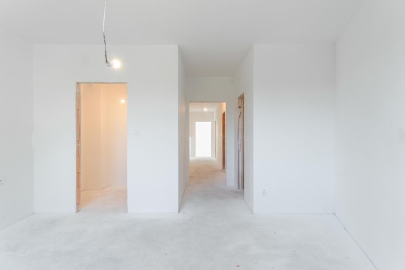 Interior of a family house with white walls and unfinished door openings.