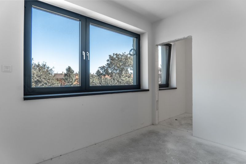 Interior of a family house with white walls and a large window overlooking the trees.