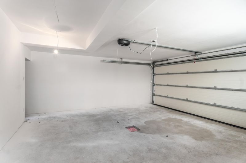 A garage in a family house with a concrete floor and electric doors.