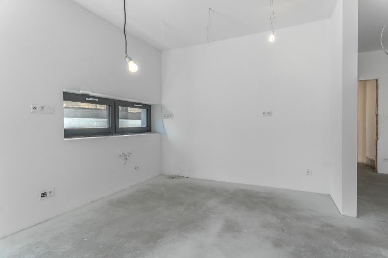 Empty room in a family house with a concrete floor and wall installation.