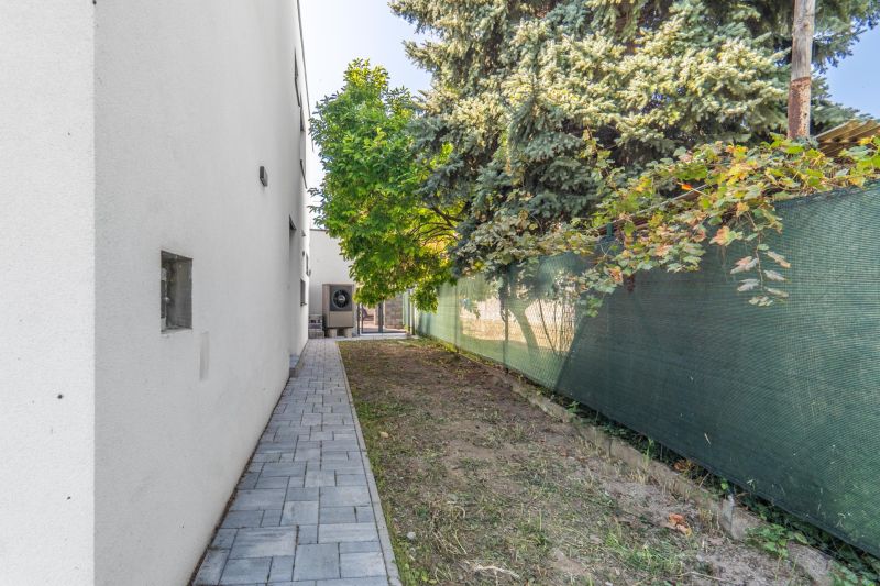 Exterior of a family house on Kľukatá Street in Bratislava - Prievoz with a sidewalk and trees.