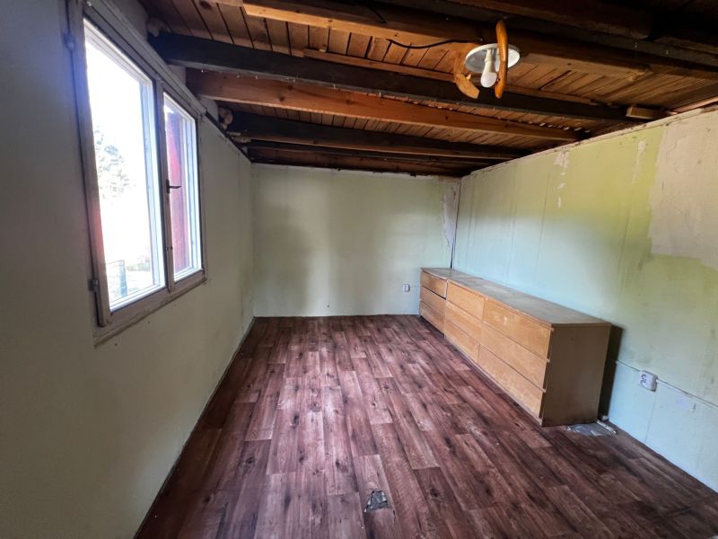 Interior of a room with a drawer chest and a wooden decor floor in Gardens.