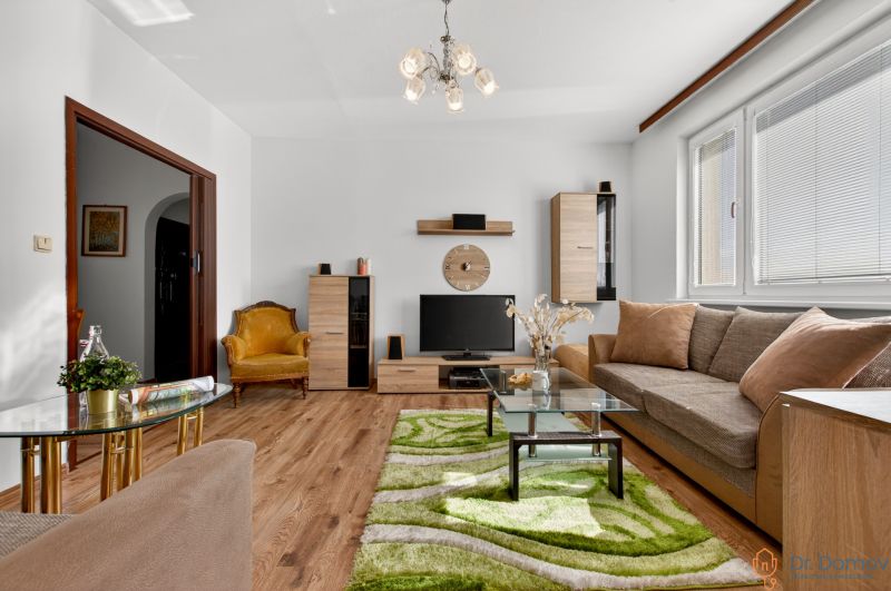 Living room in a two-room apartment with a wooden decor floor and comfortable furniture.
