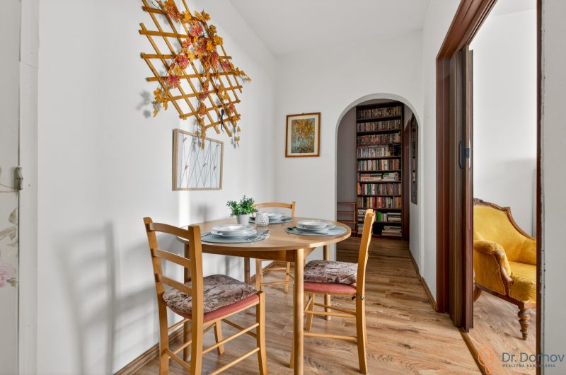 Dining area in a 2-room apartment with a wooden decor floor and wall decoration.