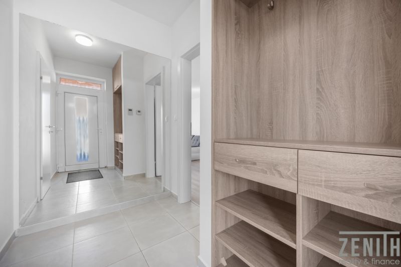 Entrance hallway in a family house with tiled flooring and wooden decor furniture.