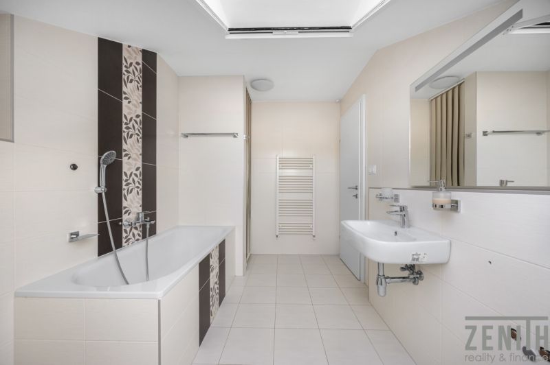 Bathroom with shower and bathtub in a family house, tiles, light-colored tiles, mirror.