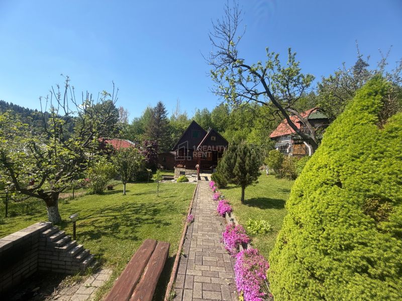 A cottage on Bukovská Road in Čadca surrounded by a beautiful garden and trees.