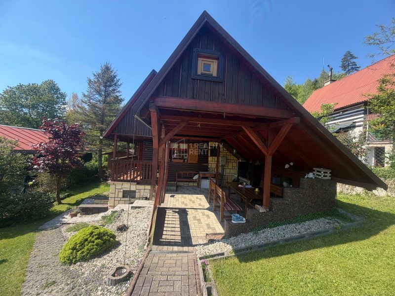 A wooden cottage on Bukovská Road in Čadca, surrounded by greenery and a garden.