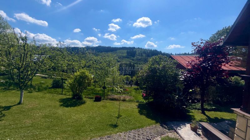 A garden by the cottage on Bukovská Road in Čadca with a view of the forest horizon.