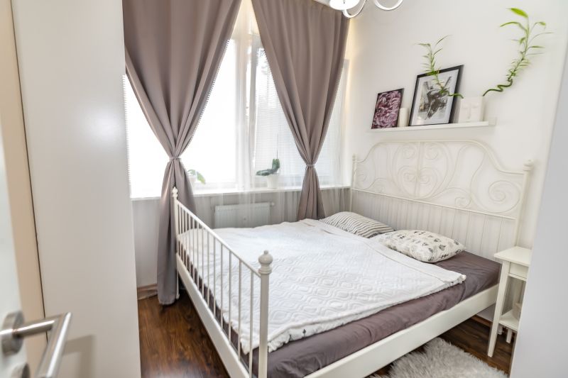 Bright bedroom with bed and decorations, 2-room apartment, wooden decor flooring.