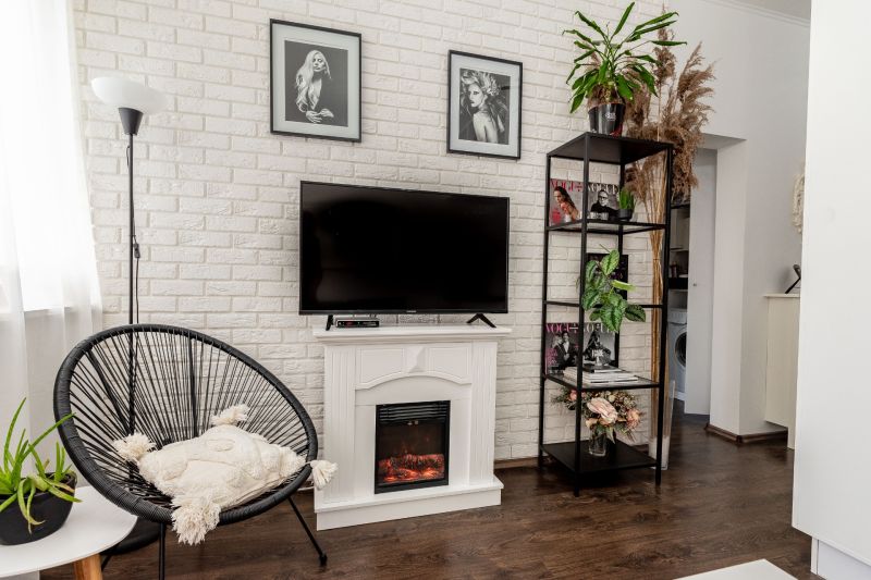 Living room with a white brick wall, decorative fireplace, black armchair, and wood-patterned flooring.