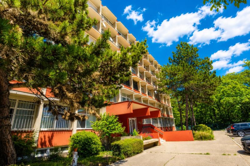 Apartment building on Vlčie Hrdlo Street in Bratislava - Ružinov surrounded by greenery and a parking lot.