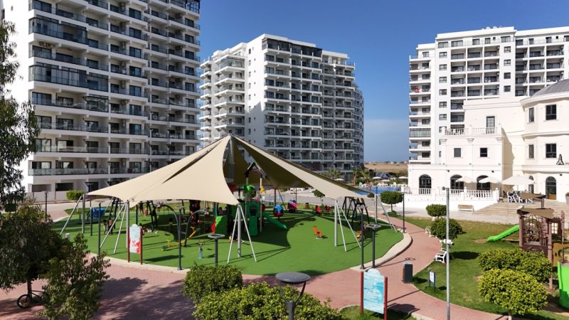 A playground surrounded by high-rise buildings in Iskele, near a studio apartment, on a sunny day.