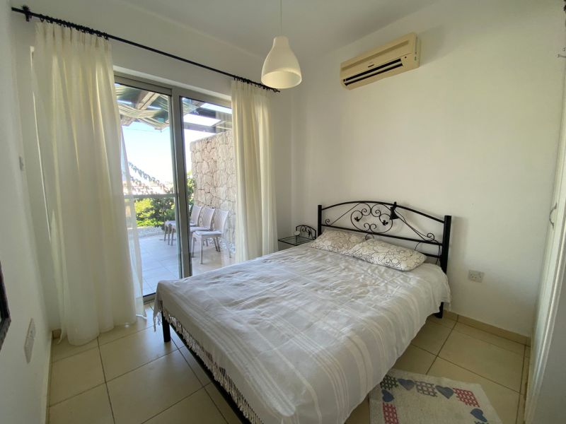 Bedroom in a 2-room apartment with a bed, air conditioning, and access to the terrace.