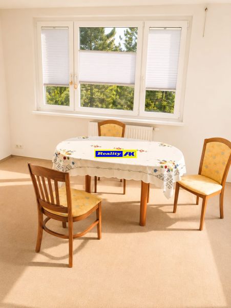 Dining room in a 3-room apartment with three chairs and a large window with a view.