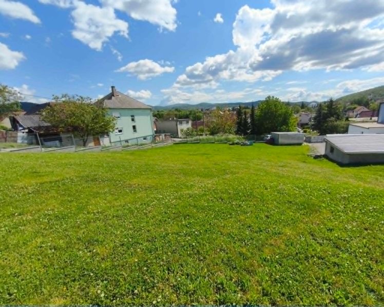 The greenery on residential plots in Horná Ves surrounds the houses and hills.