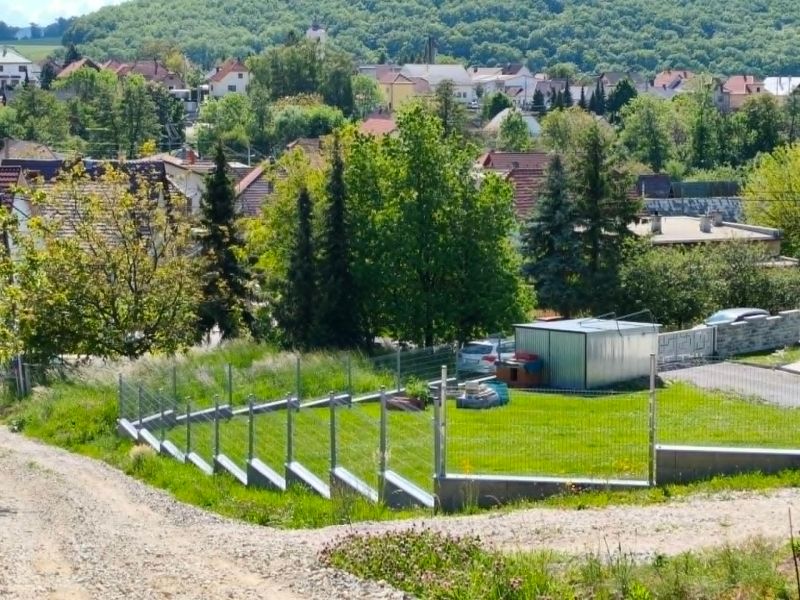 Land - housing in Horná Ves; green areas and village houses on the slope.