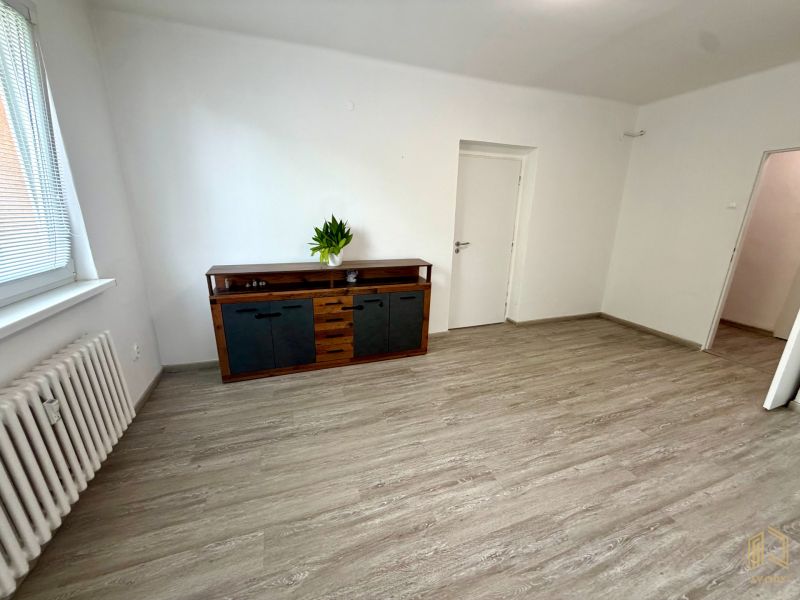 2-room apartment with a wooden decor floor and a wooden chest of drawers by the wall.