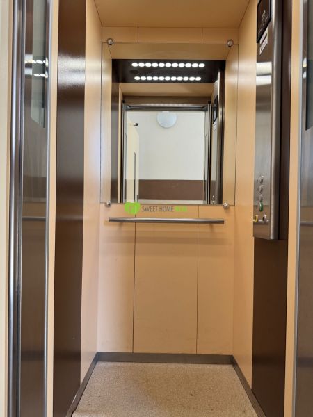 Interior of an elevator with lighting and a mirror in a 3-room apartment.