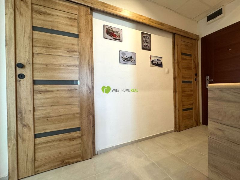 Interior of a 3-room apartment with wooden decor doors and pictures on the wall.