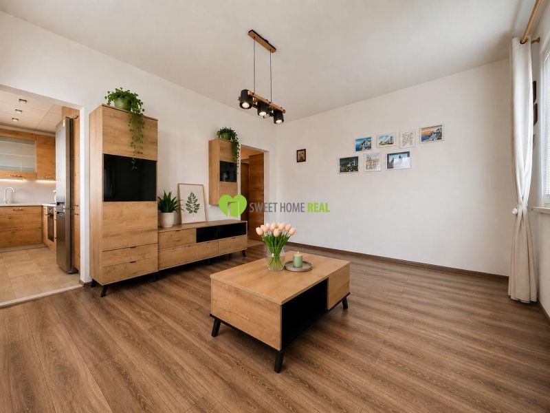 Living room of a three-room apartment with decorative wood and wood-patterned flooring.