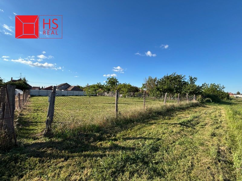 Gardens in Dvory nad Žitavou with a spacious plot and fencing, blue sky.