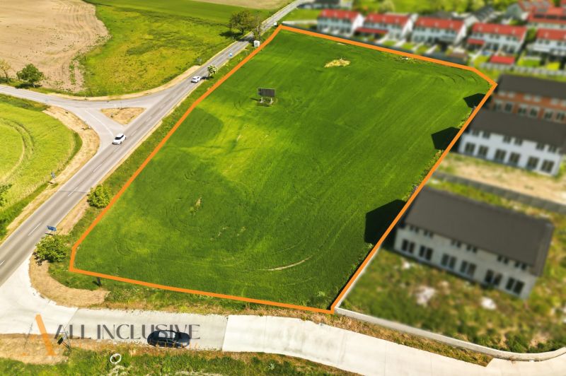 Plots - housing in Lehnice. Greenery separated by a road, surrounding construction of properties.