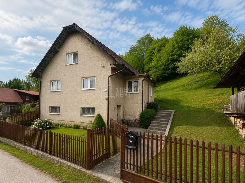A family house in Budatínska Lehota in Kysucké Nové Mesto surrounded by greenery and a fence.