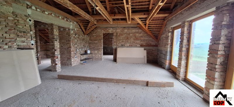 Exposed brick walls and uncovered wooden beams in a family house.