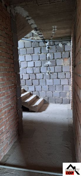A view of an unfinished staircase in a family house with brick walls.