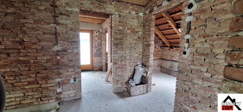 Masonry walls and roof structure in a family house without finished surfaces.