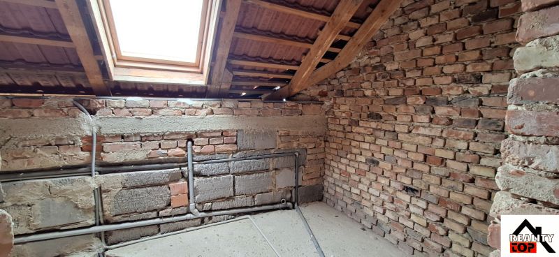 The attic of a family house with wooden beams and a skylight.