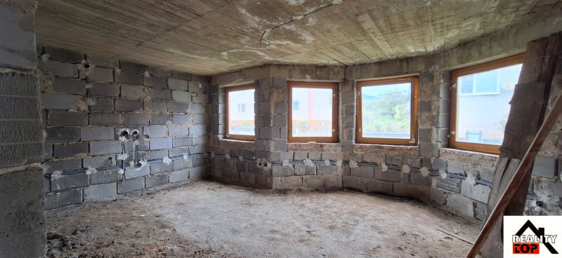 Unfinished room with windows and concrete floor in a family house.
