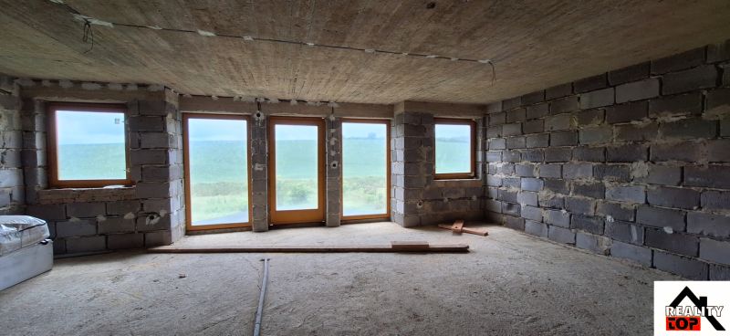 Interior of a family house with brick walls and large windows.