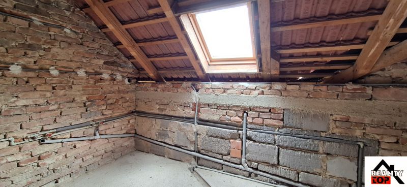 Attic floor plan with a brick wall and a skylight in a family house.