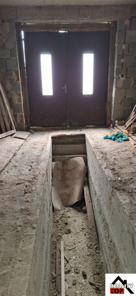Unfinished interior of a family house with main entrance door and staircase.