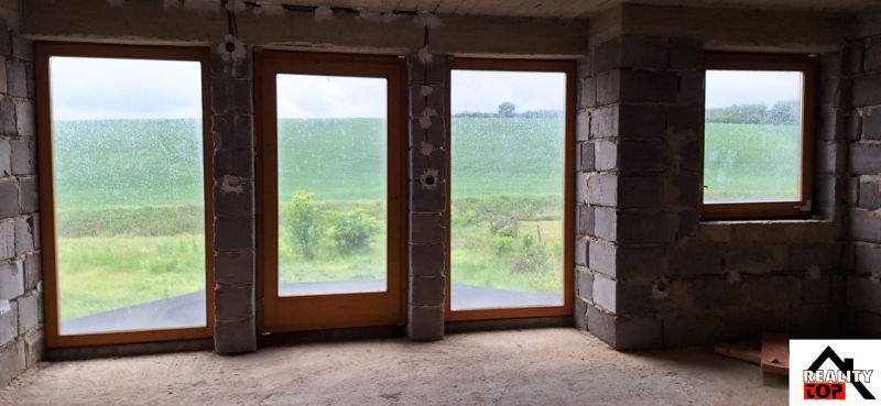 A family house with a view of the green landscape through large windows.