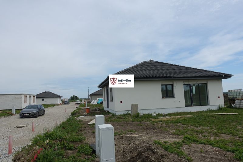 A family house in the village of Reca with a side access road and parked cars.