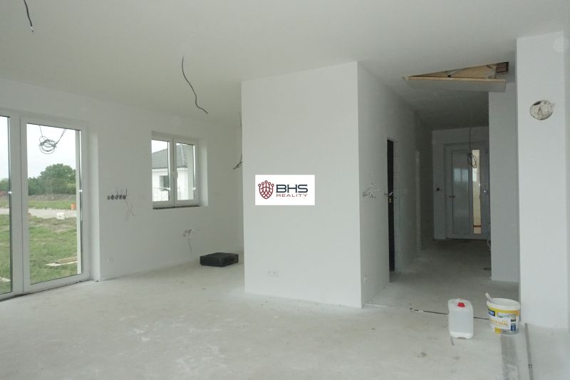 Interior of a family house with windows, preparation for floors, and white walls.