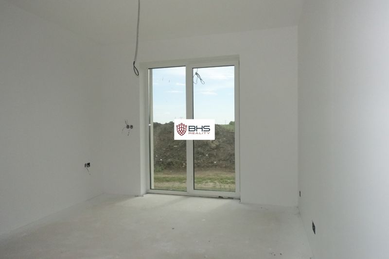 Interior of a family house with white walls and a large window without flooring.