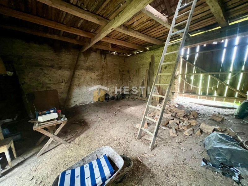Interior of a family house with a ladder, table, and wood on the floor.