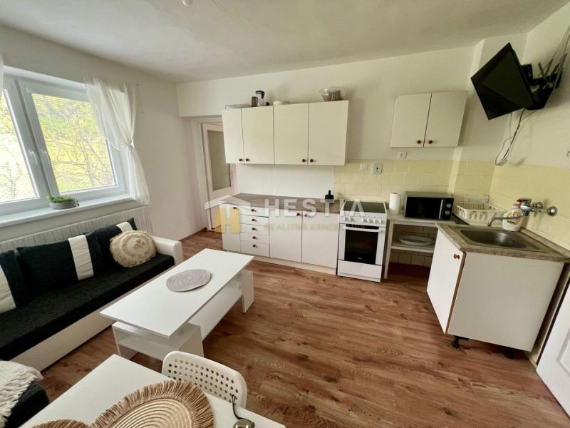 A kitchen in a family house with a wooden decor floor and white furniture.