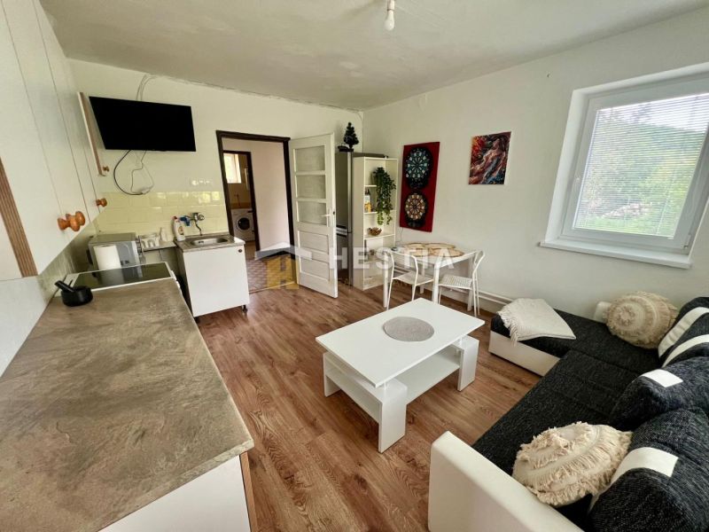 A kitchen in a family house with white furniture and a wooden decor floor.
