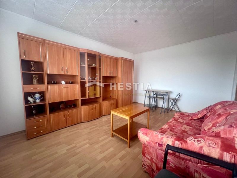 Living room in a 3-room apartment with a wooden decor floor and wooden furniture.