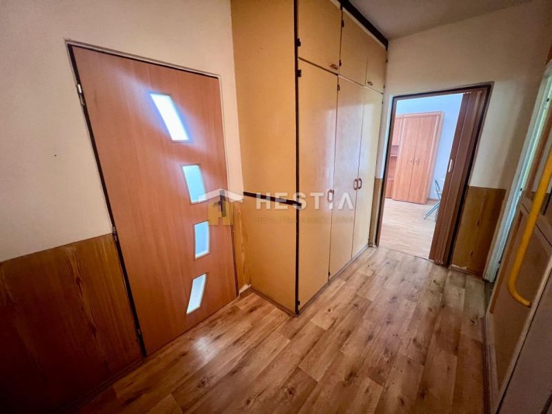 A hallway in a 3-room apartment with a wooden decor floor and storage spaces.