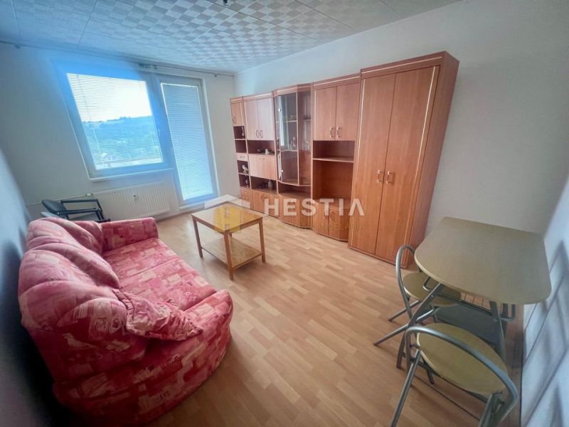 Living room in a three-room apartment with a wooden decor floor and a comfortable sofa.