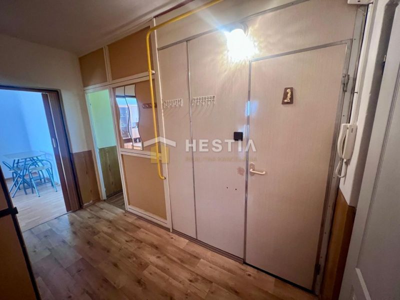 Entrance hall in a 3-room apartment with a wooden decor floor and a table with two chairs.