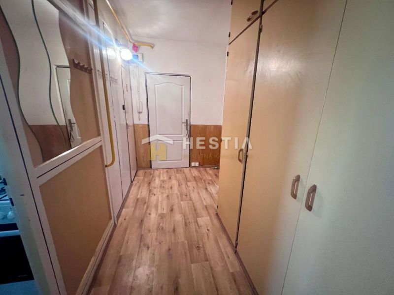 A hallway with built-in wardrobes and a floor with a wooden decor in a 3-room apartment.