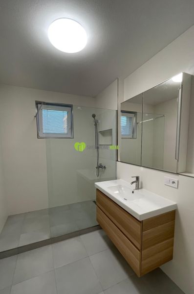 Bathroom in a 2-room apartment with a modern shower and sink.